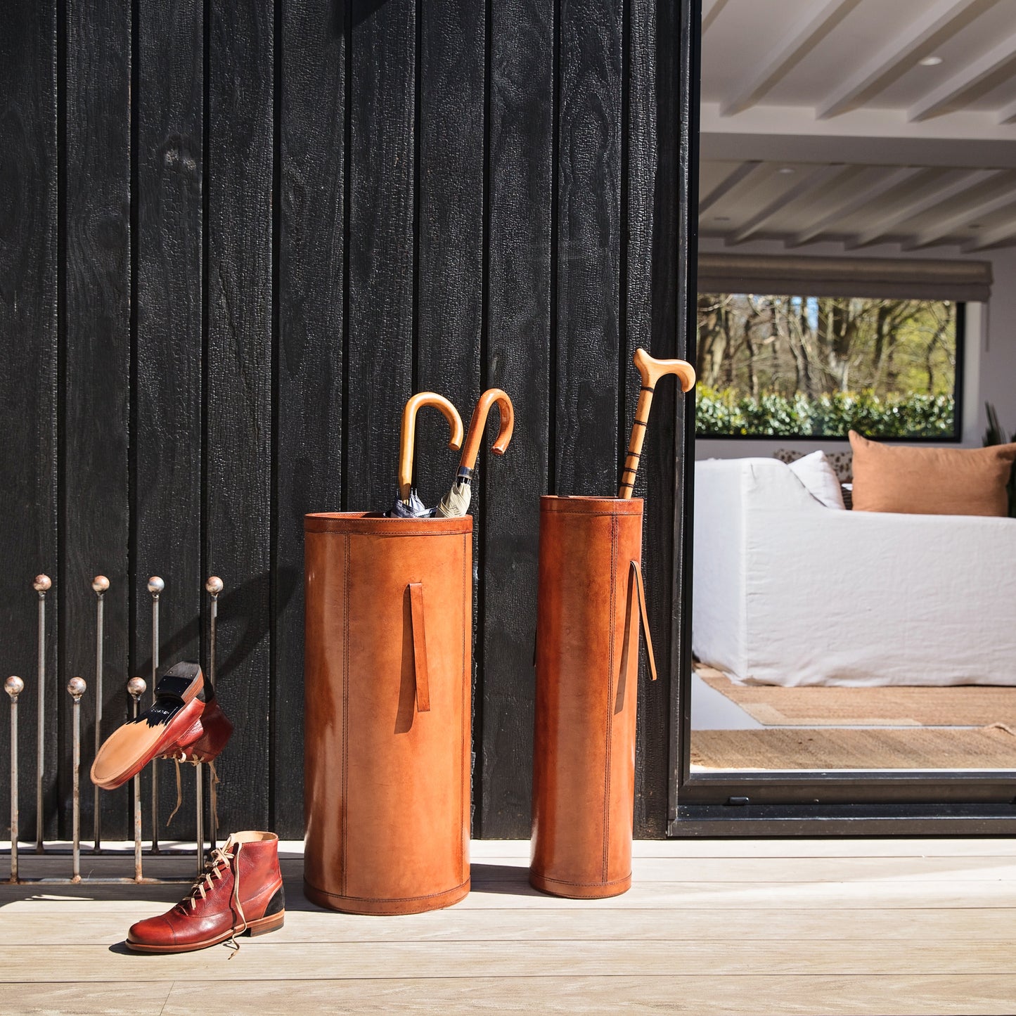Classic tan leather entrance hall set combining a tall slim stick stand and wider shorter umbrella stand with drip tray. Ideal as a gift for a new home or office.