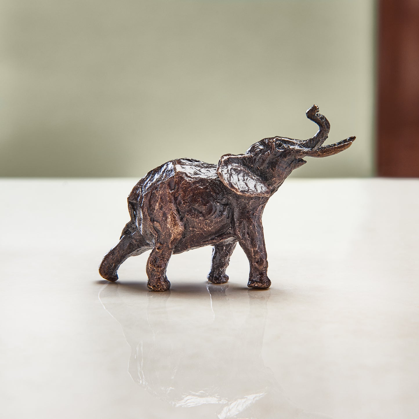 Miniature bronze figurine of an elephant. Give as a bronze anniversary gift or thoughtful birthday gift.