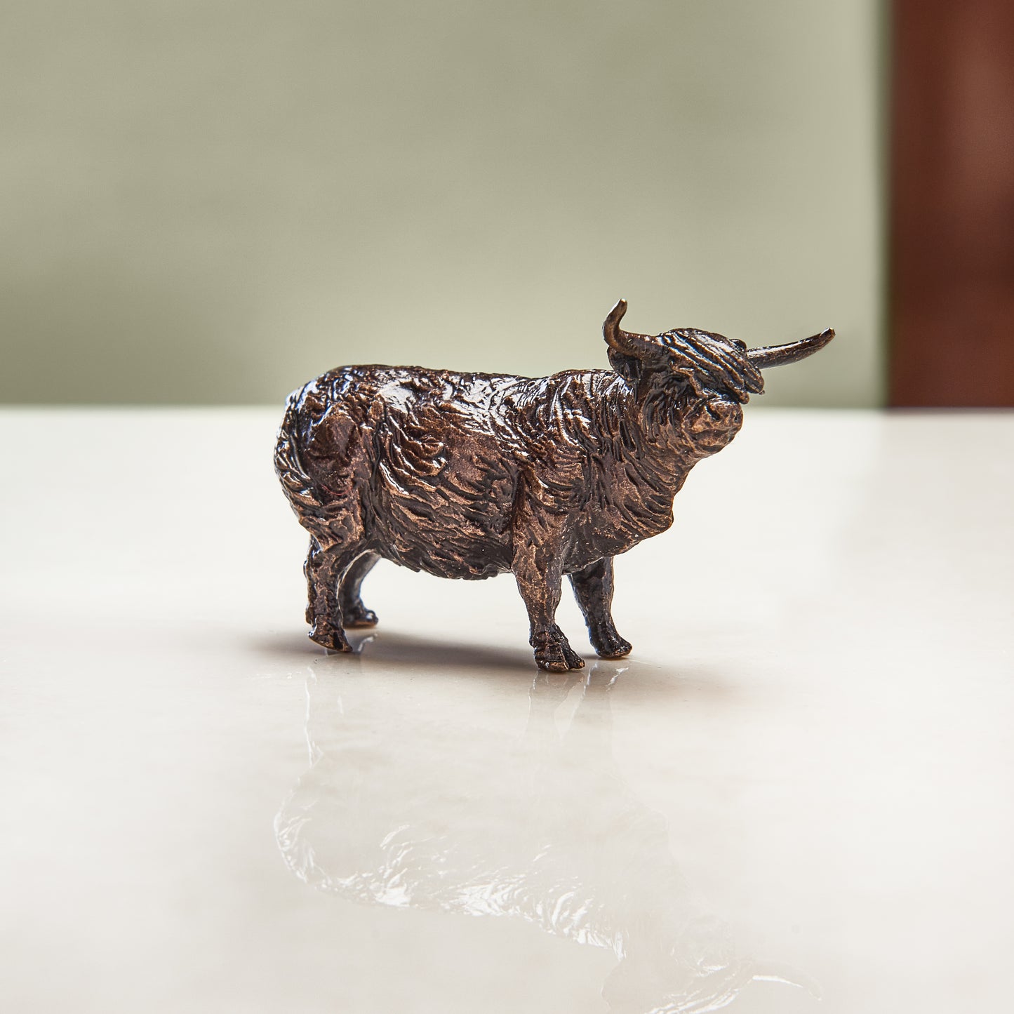 Miniature bronze figurine of a friendly highland cow. Give as a bronze anniversary gift or thoughtful birthday gift.