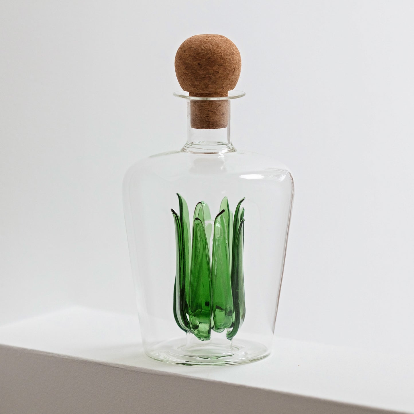 Unique glass tequila decanter with green glass agave leaves inside and a round cork stopper. Ideal as a gift for a housewarming, wedding or special birthday.