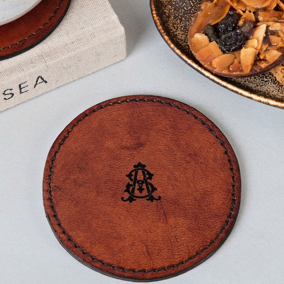Leather coaster with monogrammed initial, ideal gift for 3rd wedding leather anniversary. Will help to protect desk or bedside table surfaces.