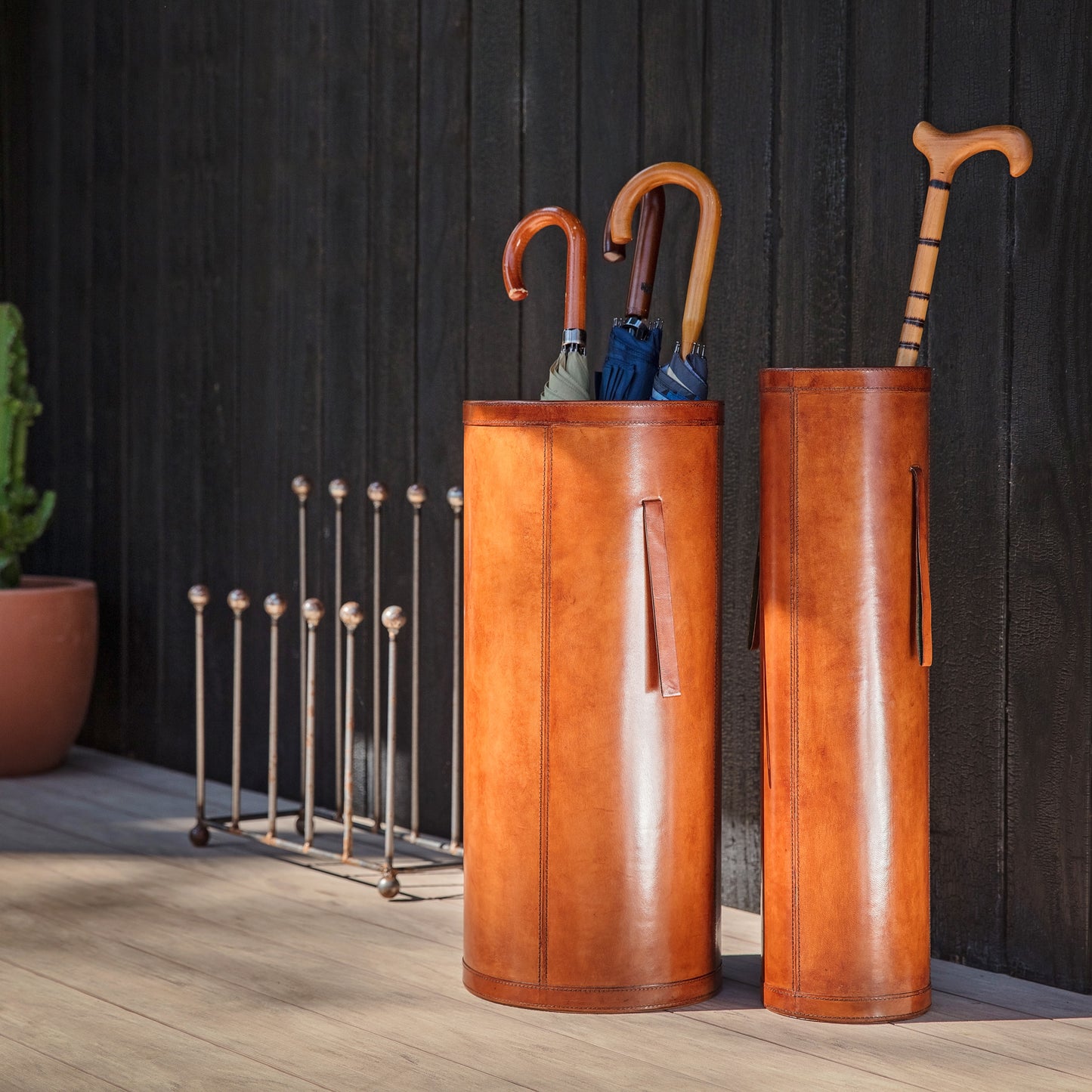 Classic cylindrical shaped tan leather umbrella stand with removable drip tray and carrying handles. Sturdy and timeless, add a personalised leather tag for a special birthday gift.