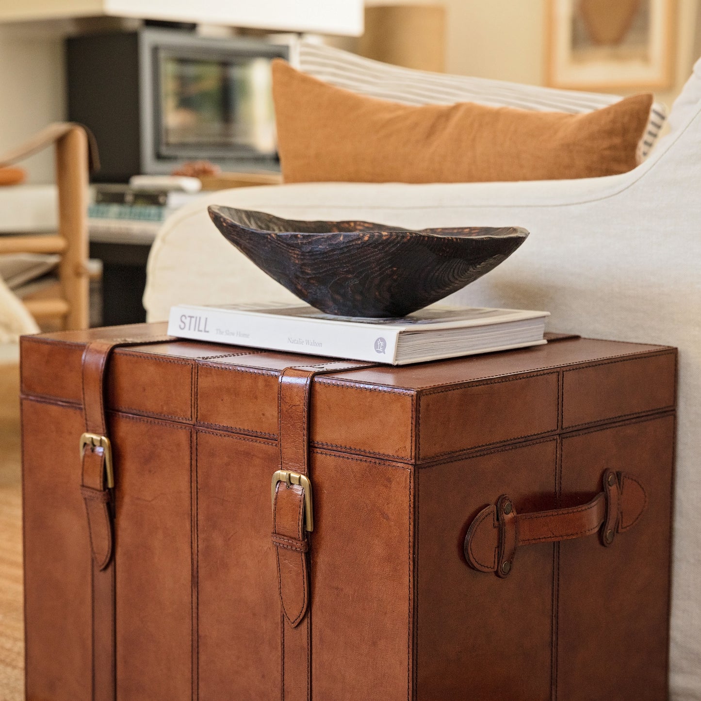 Tan leather storage trunk coffee table with buckles. Sit beside a favourite chair to use as a side table with storage for photo albums and board games. Personalise as a thoughtful new home gift.