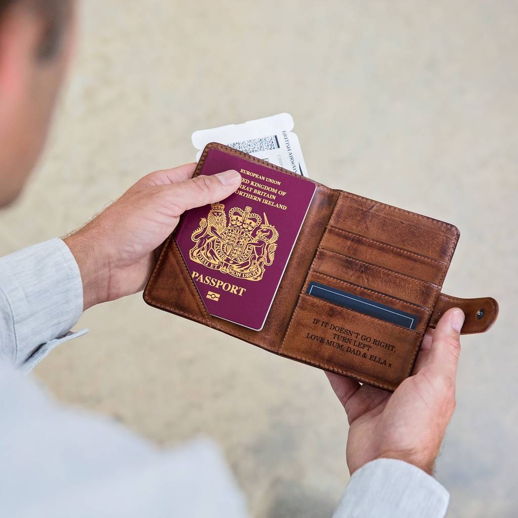 Personalised passport wallet in soft tan leather. Opens up with space for cards and currency and folds in half to close with a secure strap and press stud. Add initials or a message inside for a unique 18th birthday gift idea.