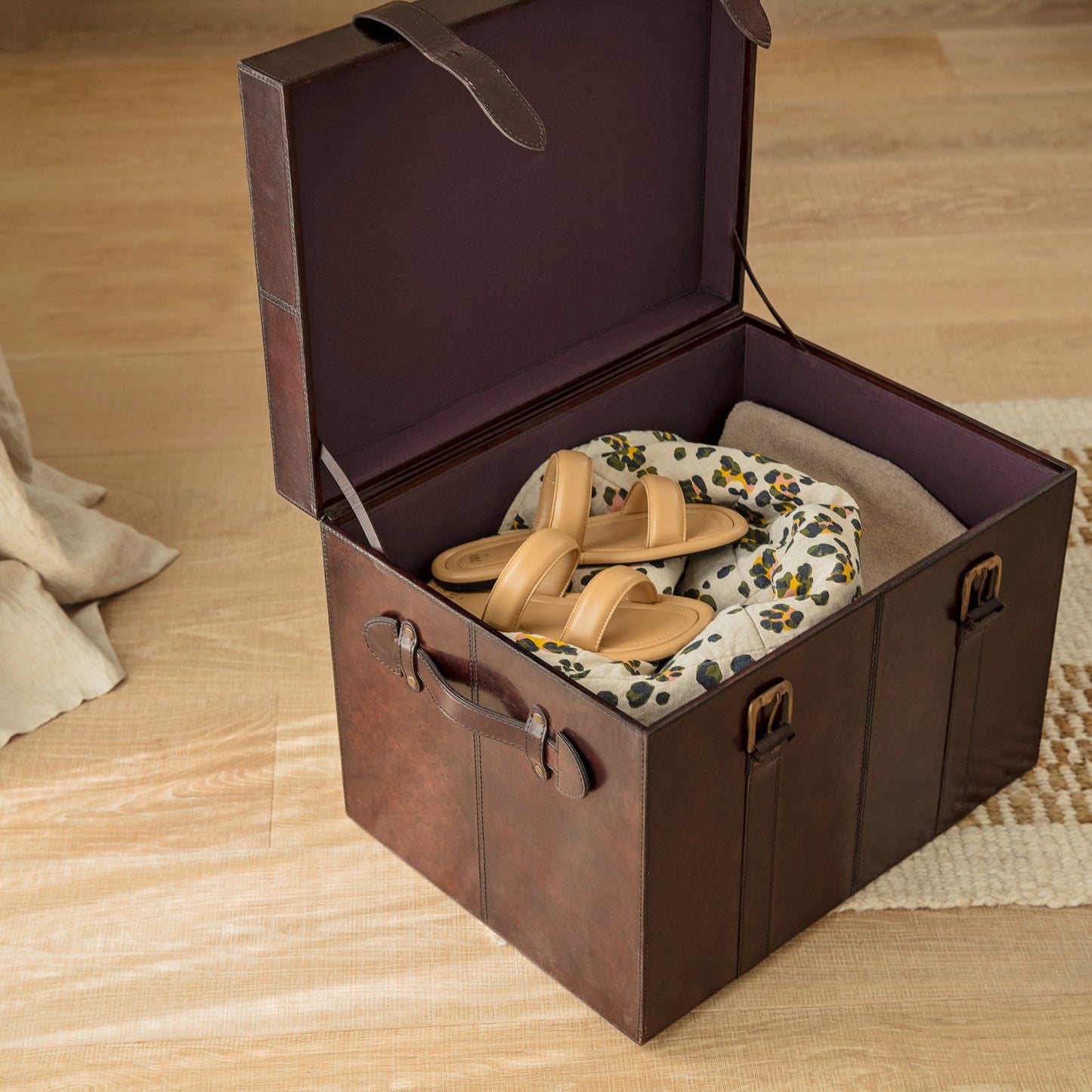 Timeless tan leather storage trunk ottoman with a lid and buckles. Use as a bedside table and personalise to create a wedding day gift to treasure forever.