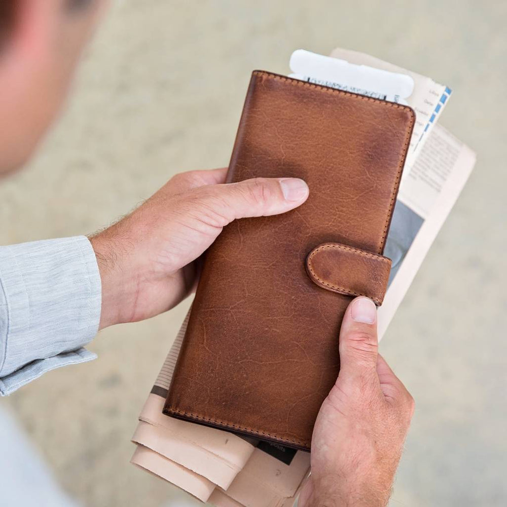 Leather travel wallet for passport and tickets. Made from soft tan leather, it closes with a secure strap and press stud and is RFID protected. Personalise for a unique father’s day gift.