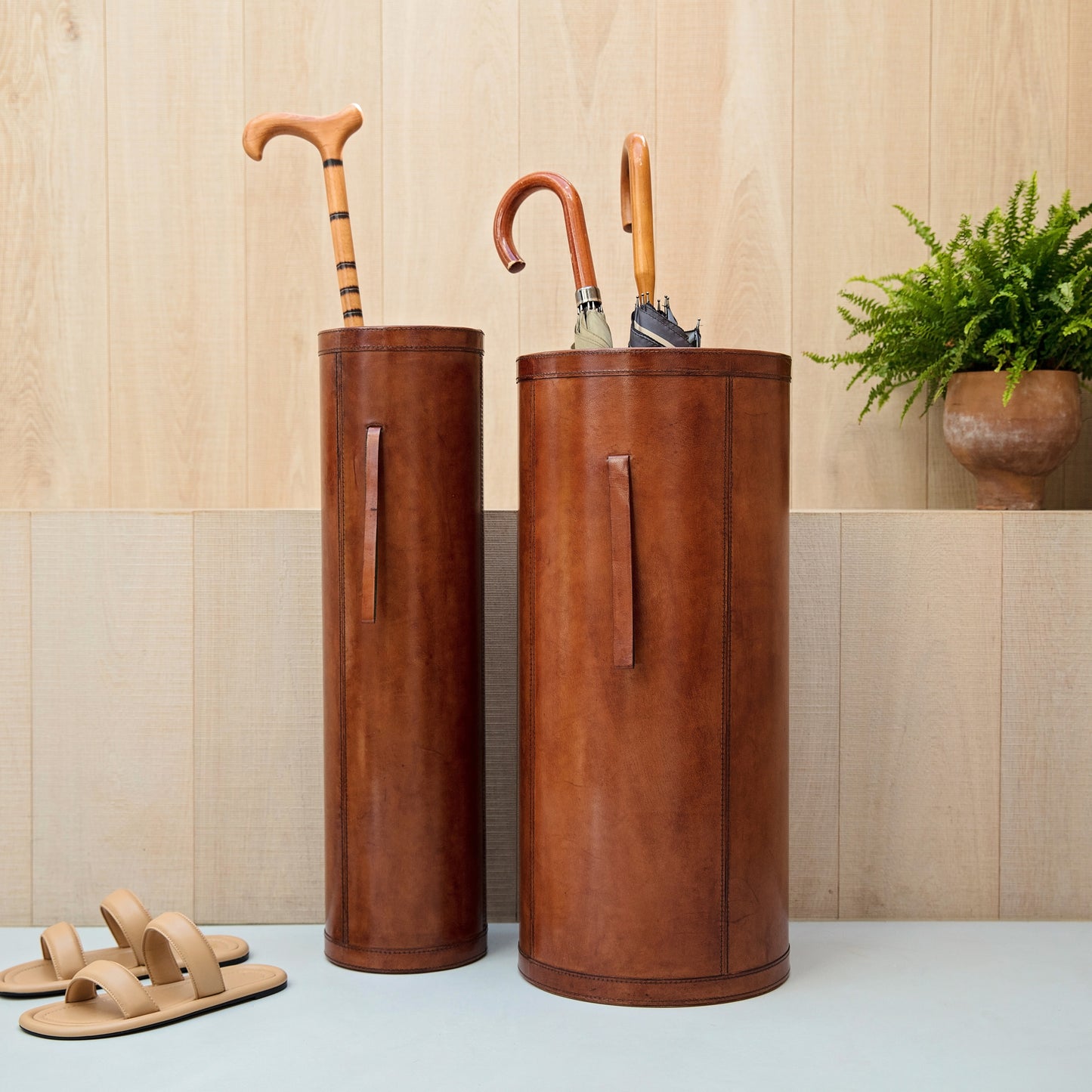 Classic cylindrical shaped tan leather umbrella stand with removable drip tray and carrying handles. Sturdy and timeless, add a personalised leather tag for a special birthday gift.