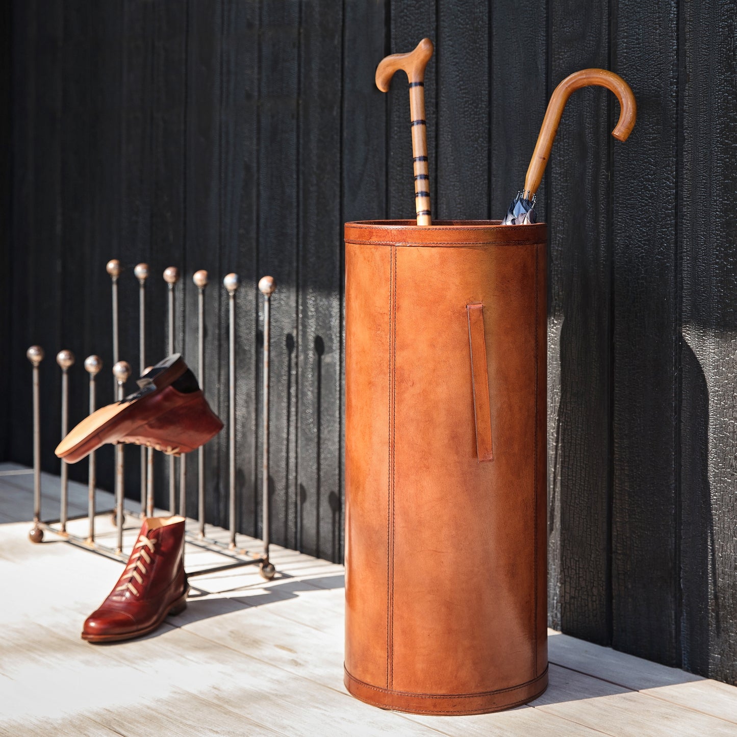 Classic cylindrical shaped tan leather umbrella stand with removable drip tray and carrying handles. Sturdy and timeless, add a personalised leather tag for a special birthday gift.