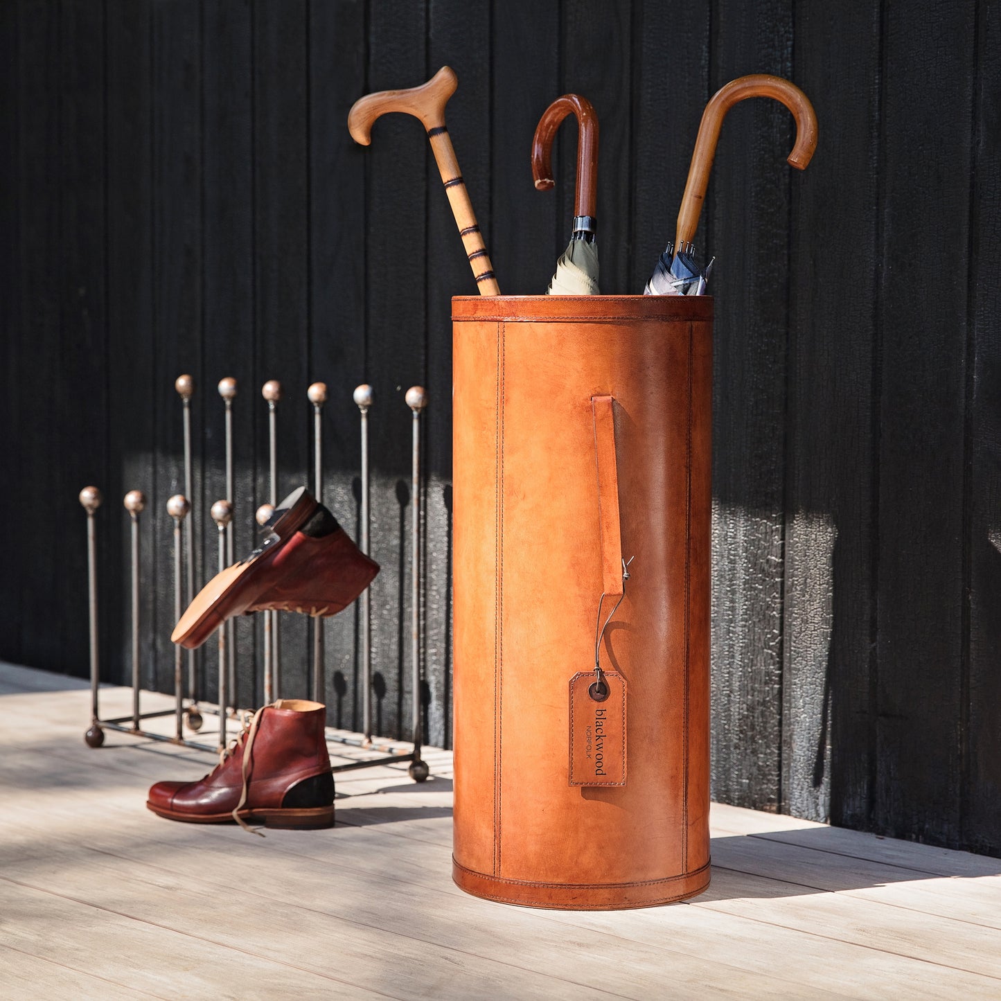 Classic cylindrical shaped tan leather umbrella stand with removable drip tray and carrying handles. Sturdy and timeless, add a personalised leather tag for a special birthday gift.