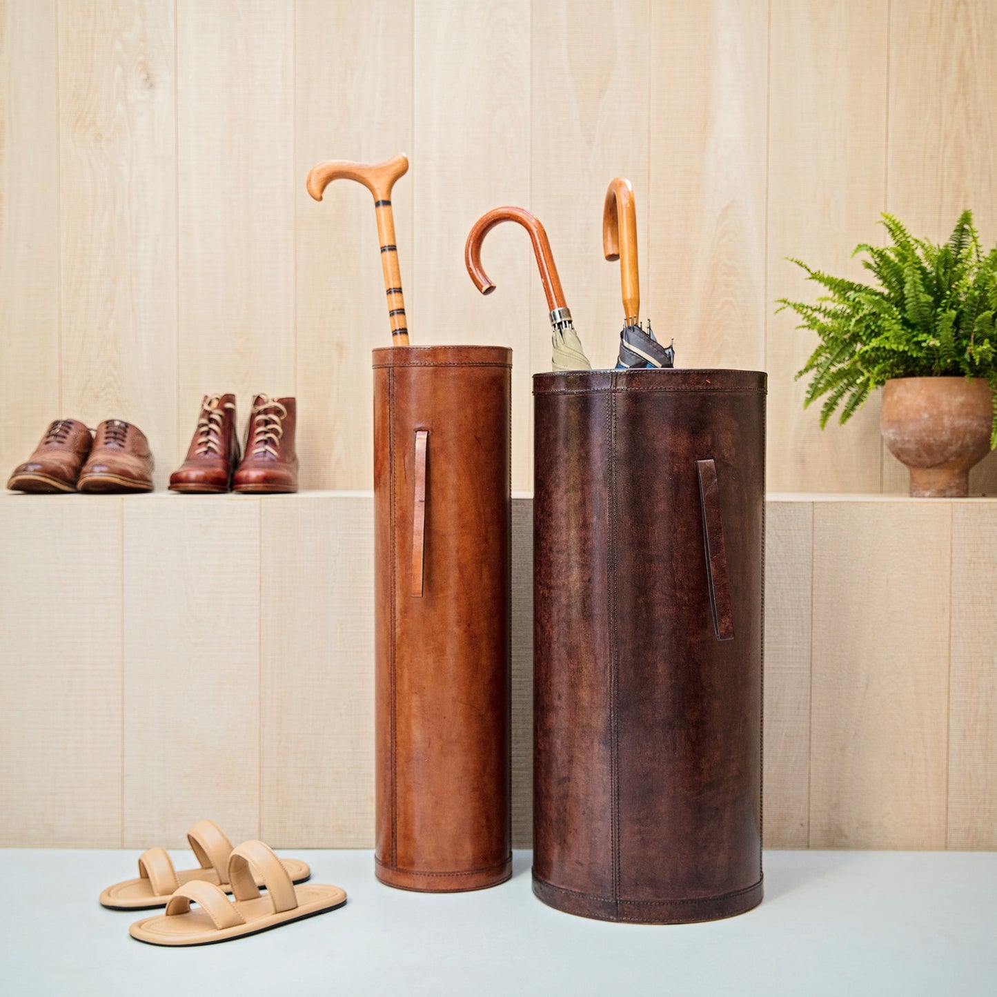 Classic cylindrical shaped tan leather umbrella stand with removable drip tray and carrying handles. Sturdy and timeless, add a personalised leather tag for a special birthday gift.