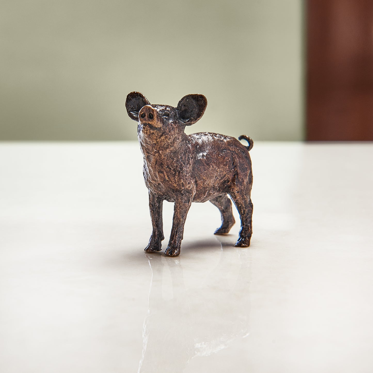 Miniature bronze pig figurine to give as a bronze anniversary gift or decorative home accessory.