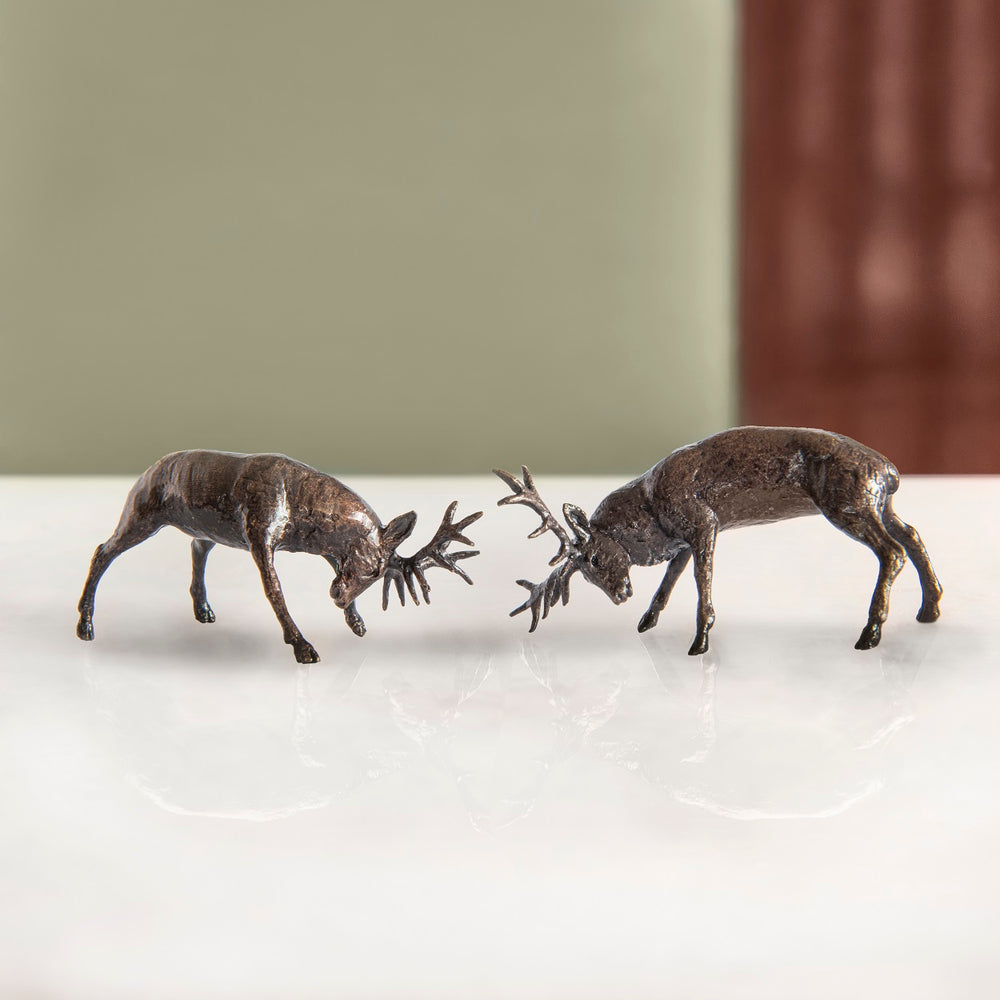 A pair of miniature bronze rutting stag figurines to give as a bronze anniversary gift or decorative home accessory.