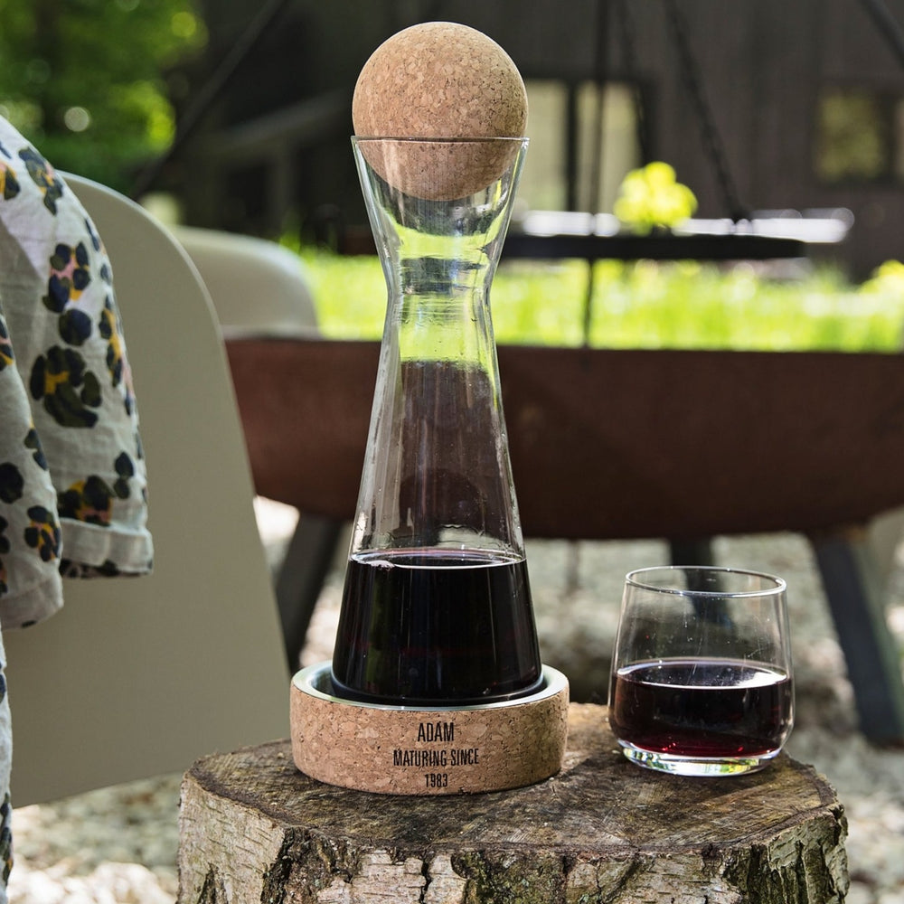 Glass carafe with cork stopper and steel wine coaster to protect surfaces from drips. Add a name or design to create a personalised milestone birthday gift. 
