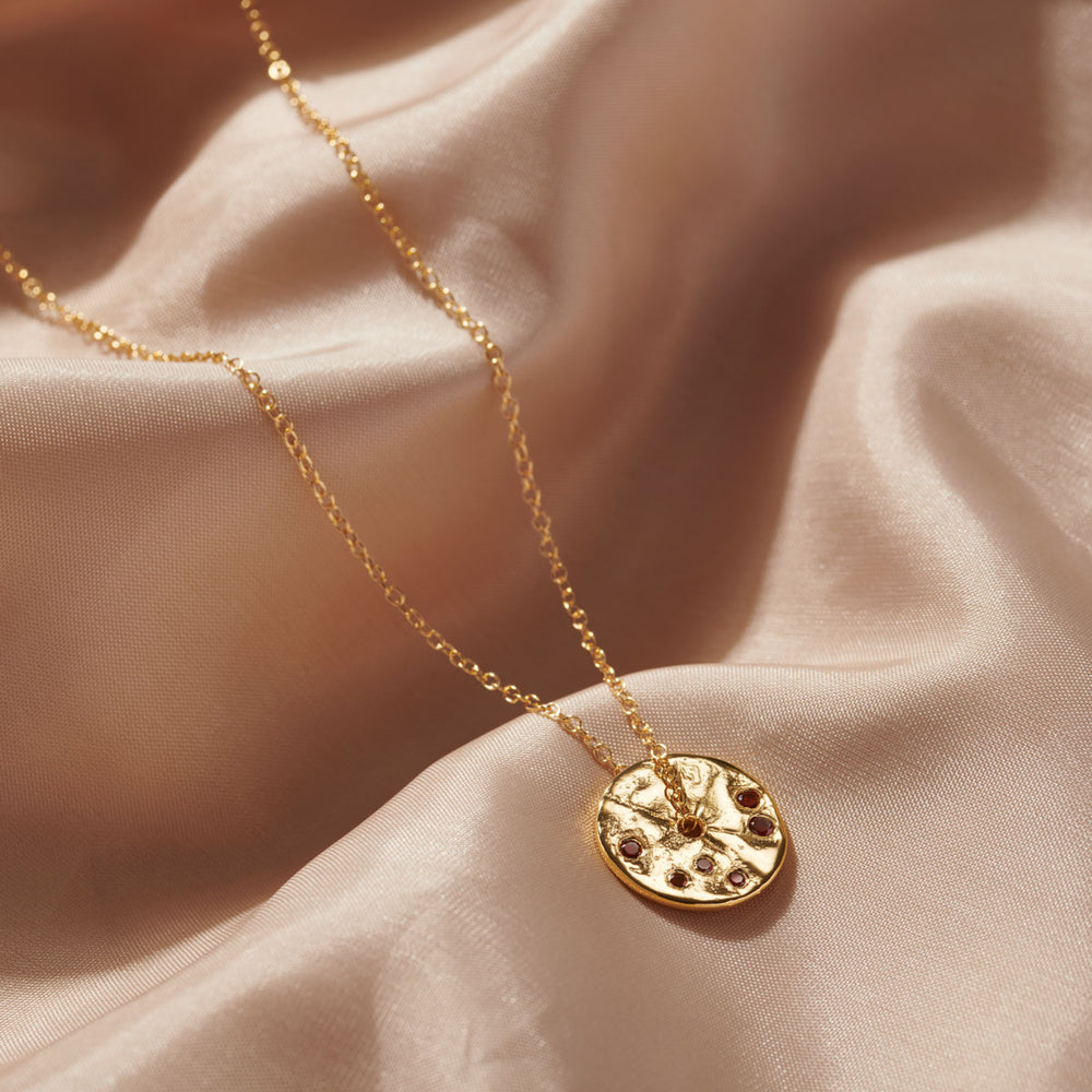 Gorgeous garnets set into a gold disc pendant on gold chain, the ideal gift for a January birthstone gift.