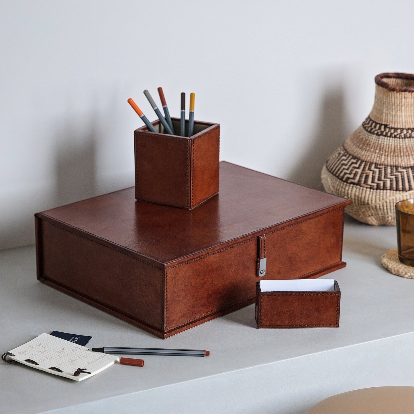 Desk accessory set in tan leather, combining a leather box file, pen pot, and business card holder. Personalise for a thoughtful and unique gift to celebrate a new job.