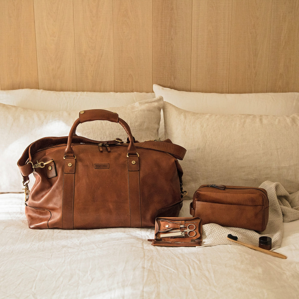 Soft tan leather weekender bag set, combining leather holdall, leather washbag and men’s manicure set. Personalise for a thoughtful 3rd wedding anniversary gift.