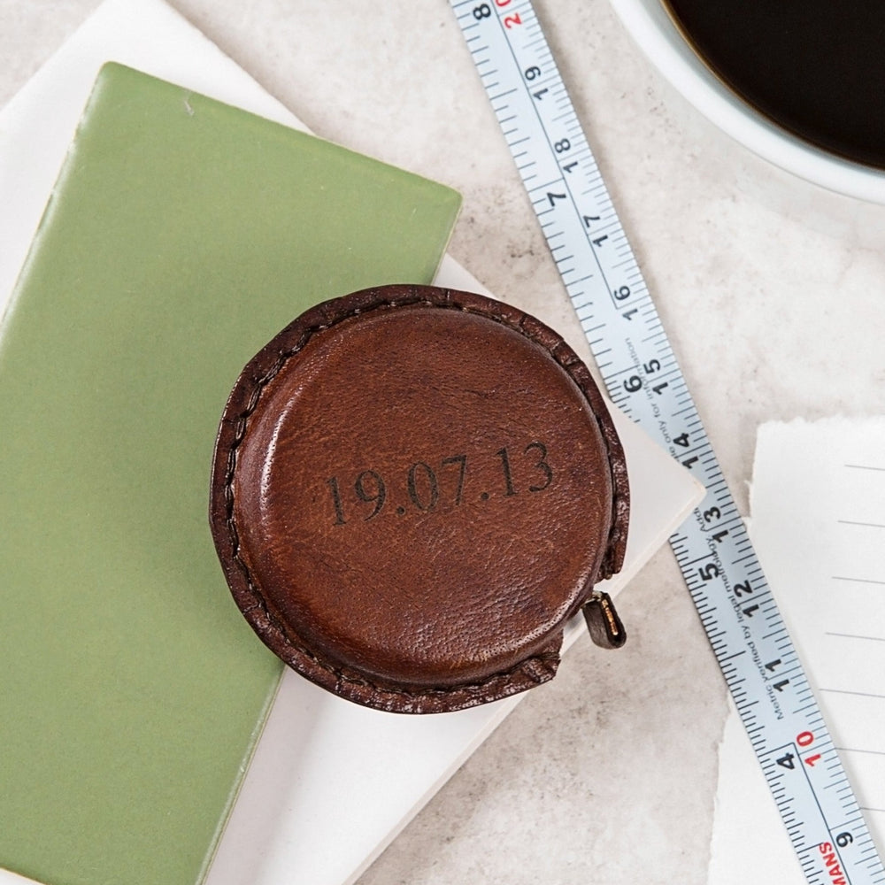 Timeless tan leather pocket sized tape measure. Add initials or a special date for a thoughtful leather anniversary gift.