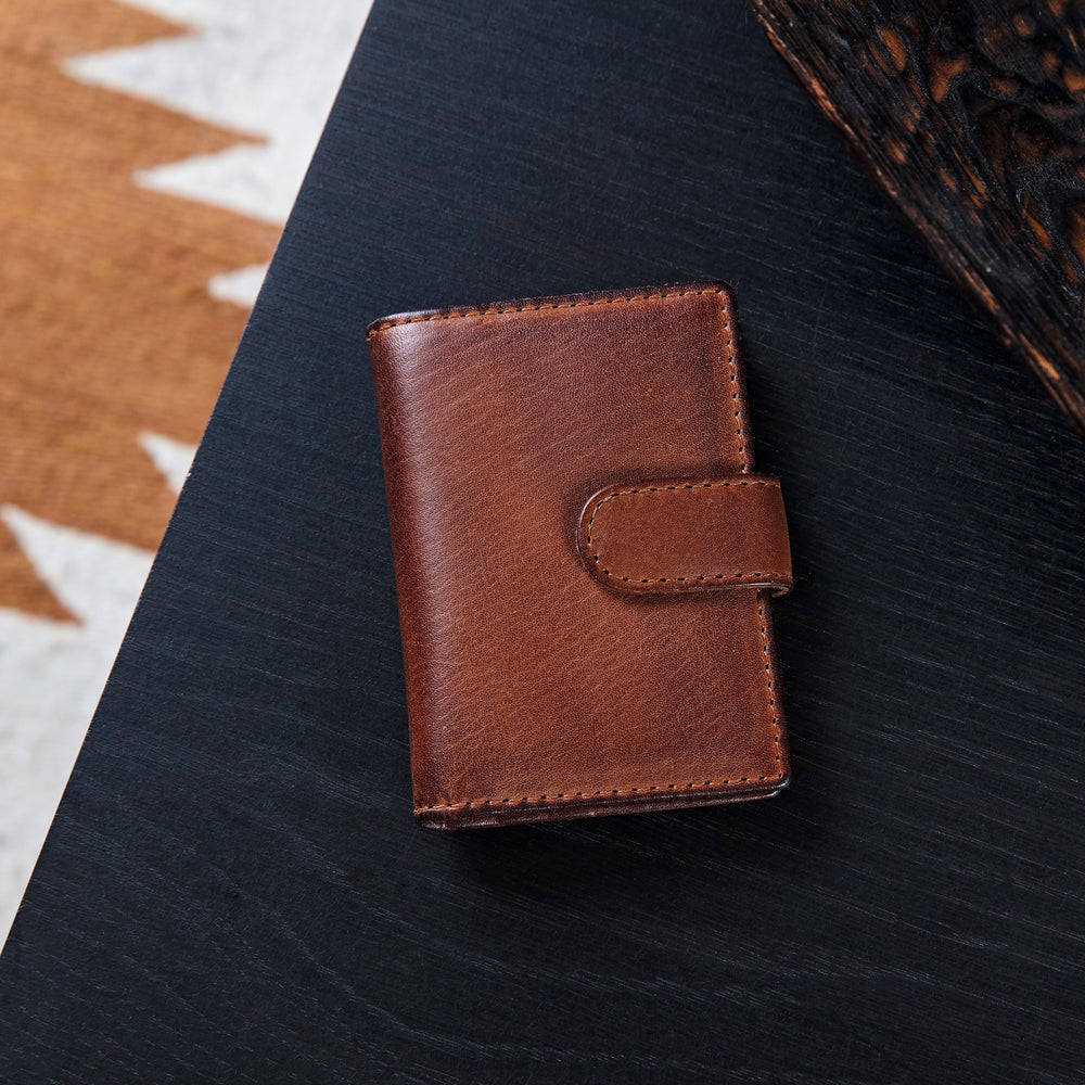 Personalised leather card wallet in soft tan leather, opens up with space for cards and notes and folds in half to close with a secure strap and press stud. Add initials or a message inside for an 18th birthday gift or unique father’s day gift.