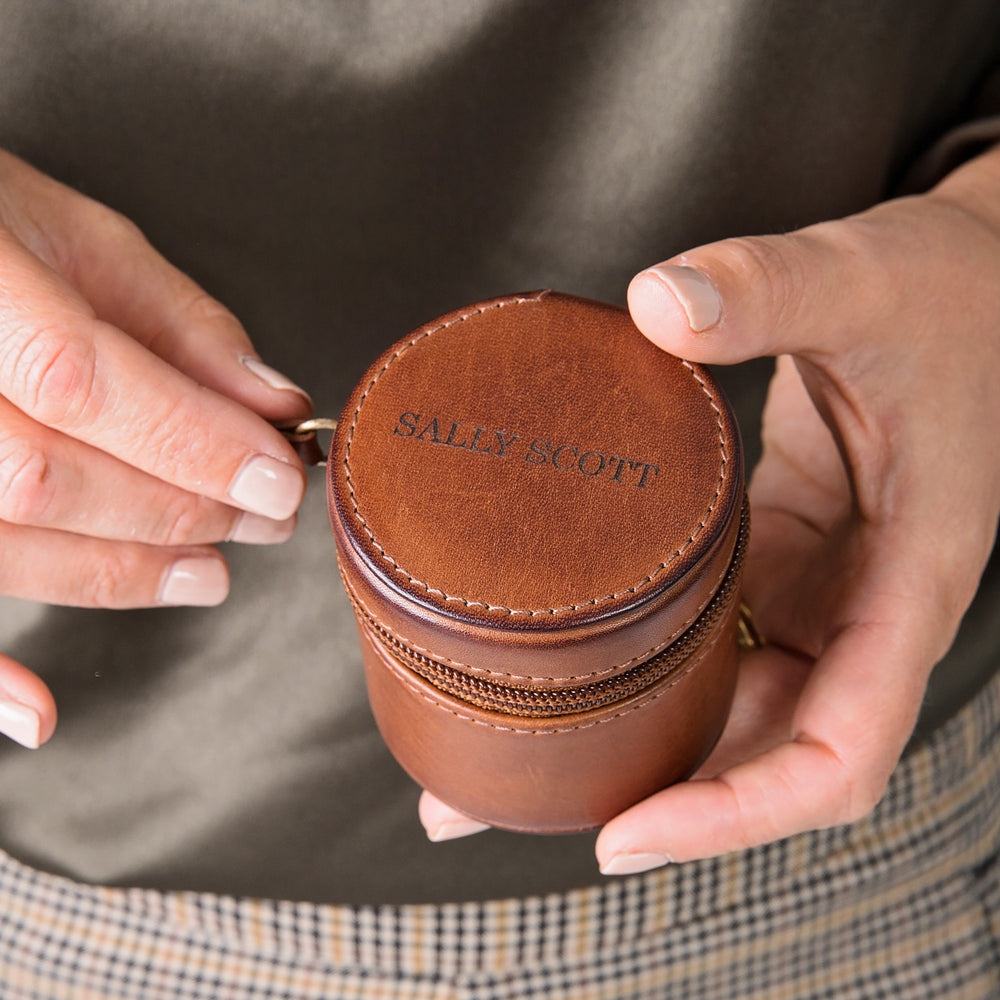 Small round travel jewellery case in soft tan leather with zip closure. Ideal for small jewellery whilst travelling. Personalise with a name, or date as a thoughtful anniversary or birthday gift.